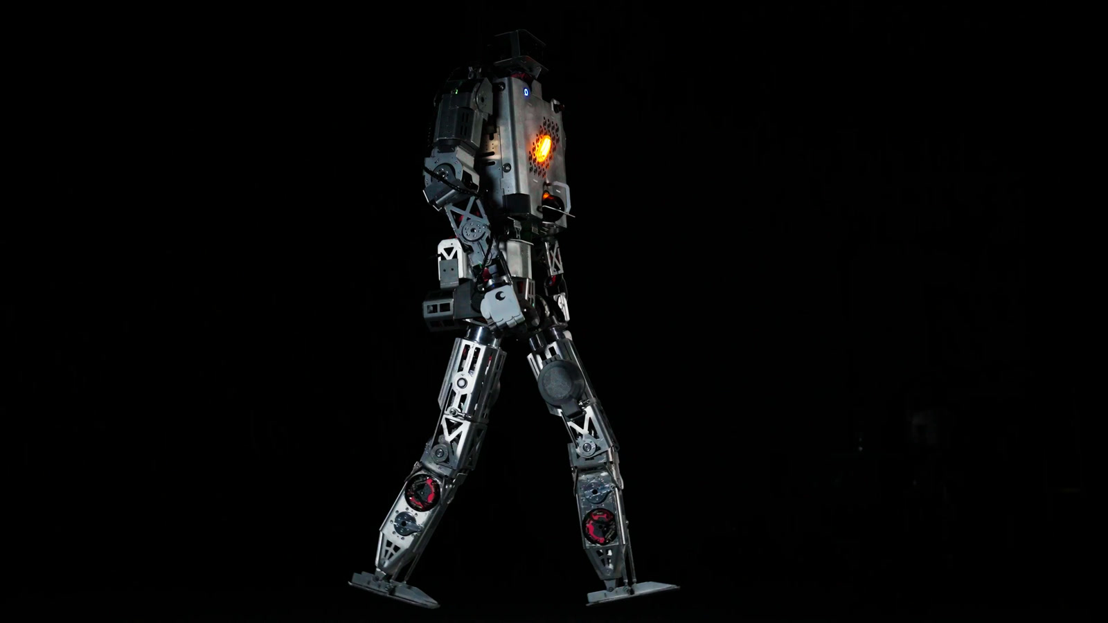 Roger, Minerva’s humanoid robot, walking on a dark stage